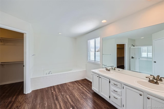 bathroom with vanity, independent shower and bath, and wood-type flooring