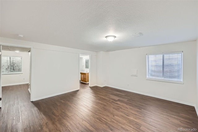 unfurnished room featuring a textured ceiling and dark hardwood / wood-style floors