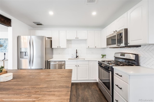 kitchen featuring white cabinets, stainless steel appliances, a sink, and light countertops