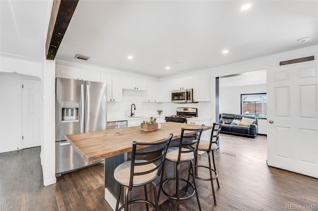 1742 S Alcott St, Denver, CO 80219 - kitchen featuring stainless steel appliances, butcher block countertops, dark wood-style floors, white cabinets, and backsplash