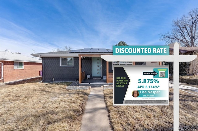 1742 S Alcott St, Denver, CO 80219 - view of front of home with roof mounted solar panels and brick siding