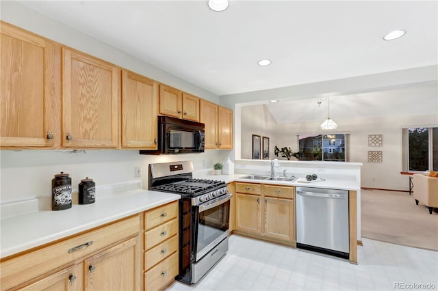 kitchen featuring sink, pendant lighting, lofted ceiling, light brown cabinetry, and appliances with stainless steel finishes