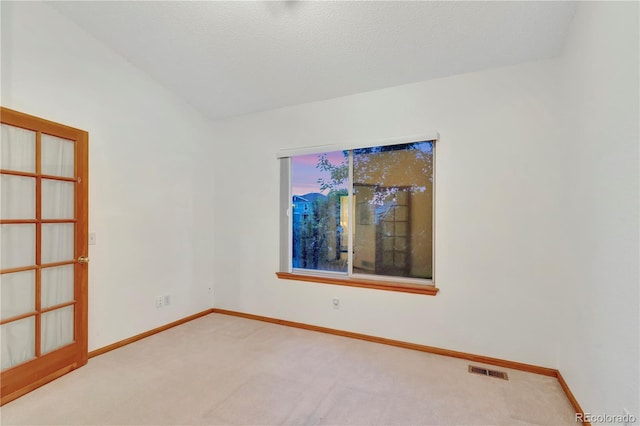 spare room with visible vents, carpet, baseboards, and a textured ceiling