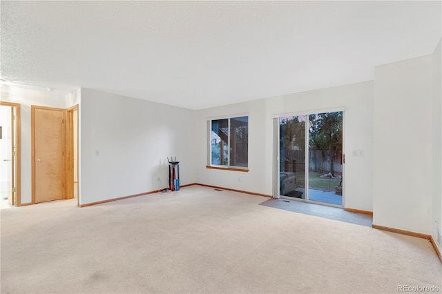 spare room featuring carpet and baseboards