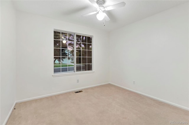 spare room featuring visible vents, carpet floors, baseboards, and a ceiling fan