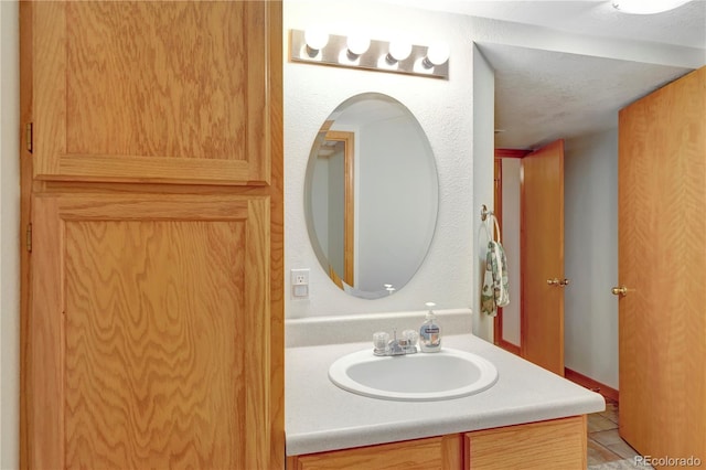 bathroom with vanity, a textured ceiling, and tile patterned flooring