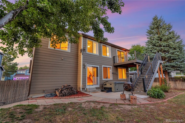 back of property with entry steps, a patio, fence, a wooden deck, and stairs