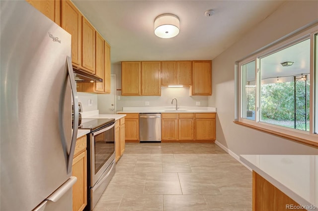 kitchen with appliances with stainless steel finishes, light brown cabinetry, and sink