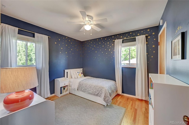 bedroom with ceiling fan and light wood-type flooring