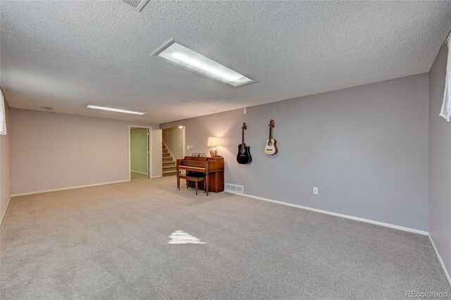 carpeted spare room featuring a textured ceiling