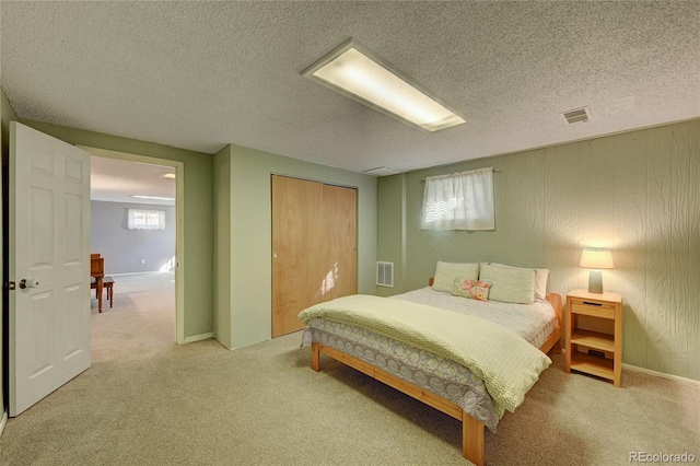 bedroom featuring a textured ceiling, a closet, and carpet flooring