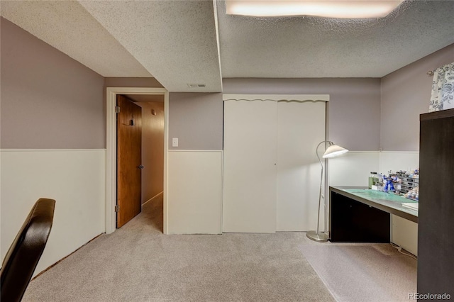 unfurnished bedroom featuring light carpet and a textured ceiling