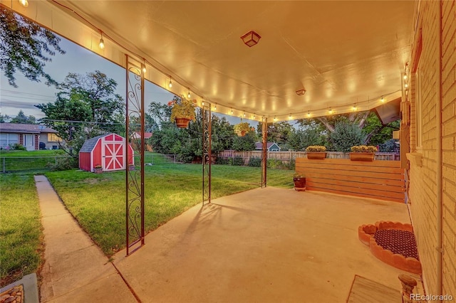 patio terrace at dusk with a shed and a lawn