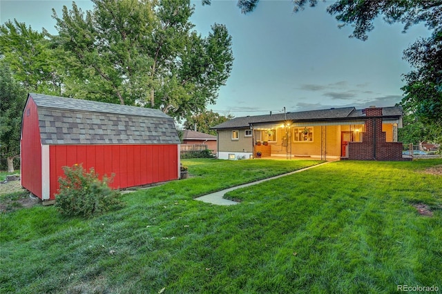 yard at dusk featuring a storage shed