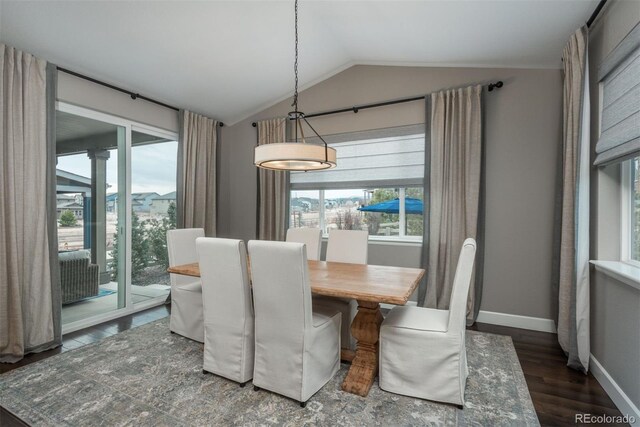 dining area featuring vaulted ceiling, baseboards, and wood finished floors