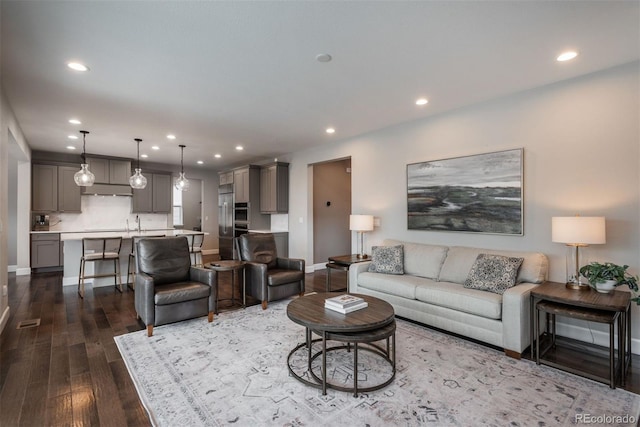 living room featuring visible vents, baseboards, dark wood-style flooring, and recessed lighting