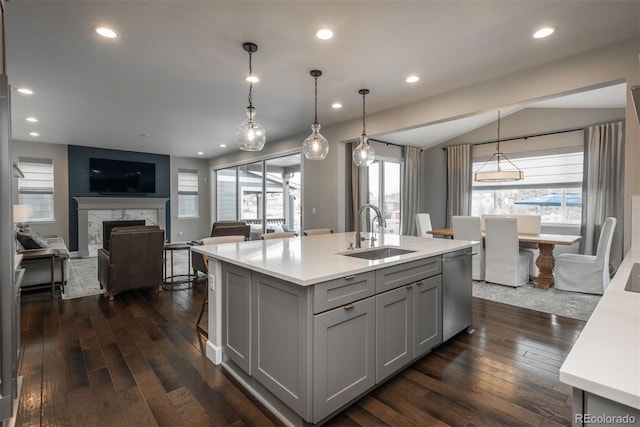 kitchen with gray cabinets, light countertops, a sink, and stainless steel dishwasher