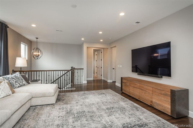 living room featuring recessed lighting, wood finished floors, baseboards, and an inviting chandelier