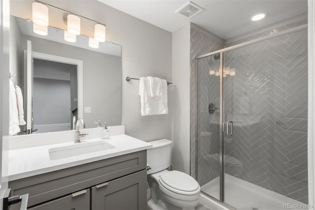 full bath with toilet, a stall shower, vanity, and visible vents