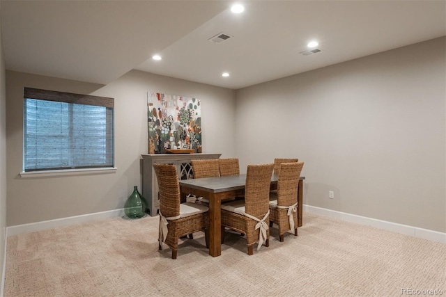 dining space with baseboards, visible vents, and light colored carpet