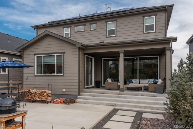 back of property featuring outdoor lounge area, solar panels, and a patio