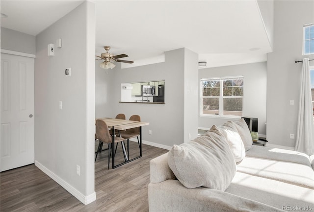 living area with ceiling fan, wood finished floors, and baseboards