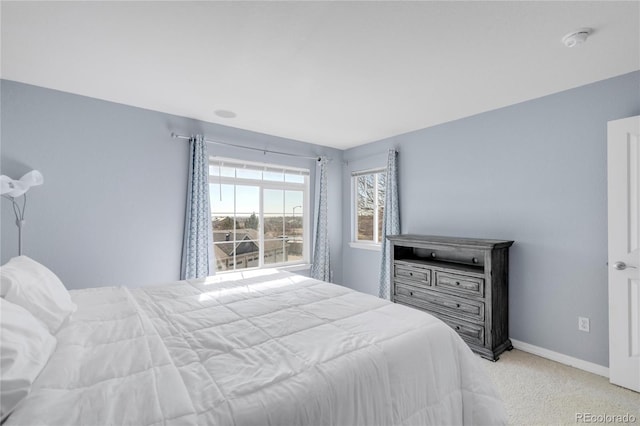 bedroom featuring light carpet and baseboards