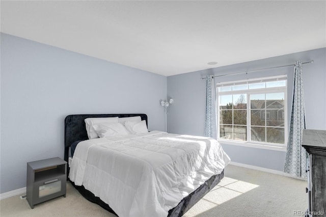 bedroom featuring light carpet and baseboards