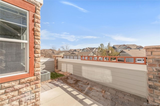 view of patio with a residential view, fence, and cooling unit