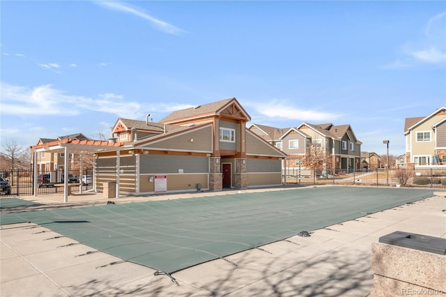 community pool with a residential view, a patio area, and fence