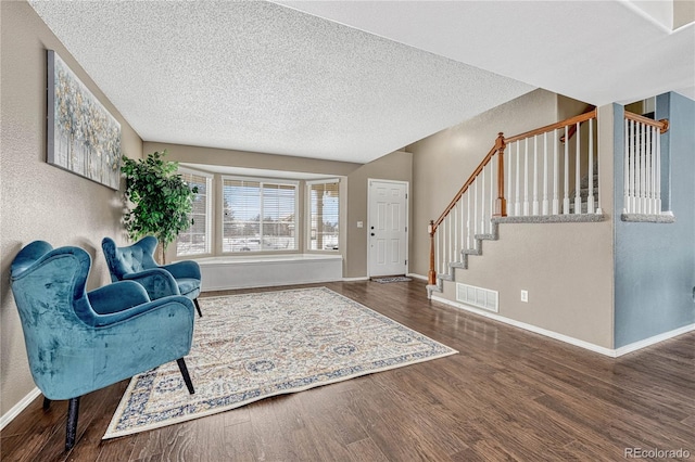 foyer entrance with a textured ceiling and dark hardwood / wood-style flooring