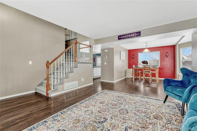 living room with dark wood-type flooring and a textured ceiling