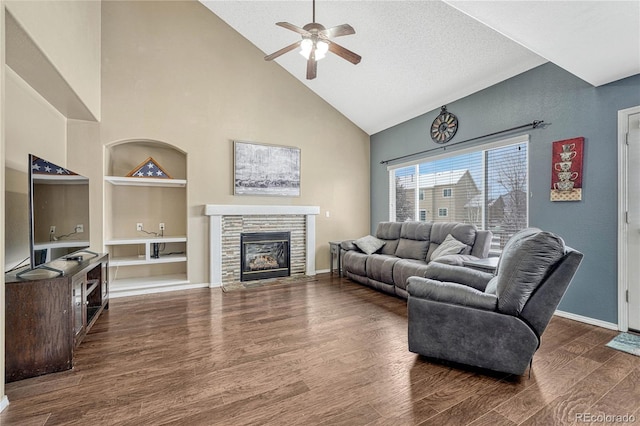 living room featuring dark hardwood / wood-style flooring, a textured ceiling, ceiling fan, built in features, and a fireplace