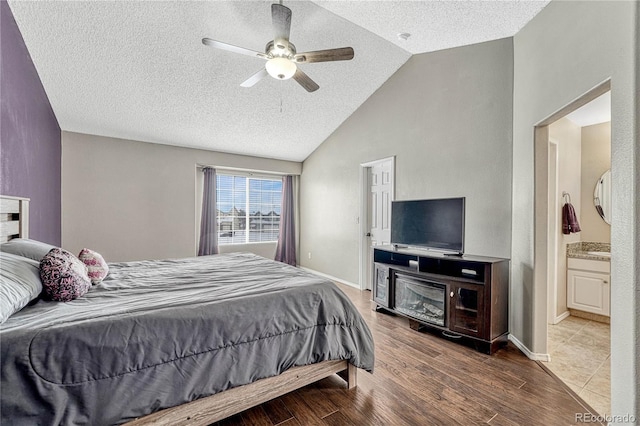 bedroom with ensuite bath, ceiling fan, and lofted ceiling