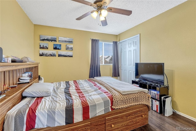 bedroom featuring a textured ceiling, dark hardwood / wood-style flooring, a closet, and ceiling fan