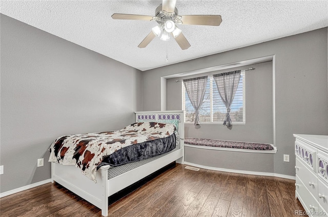 bedroom with ceiling fan, dark hardwood / wood-style flooring, and a textured ceiling