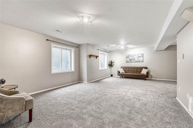 living area with carpet and a textured ceiling