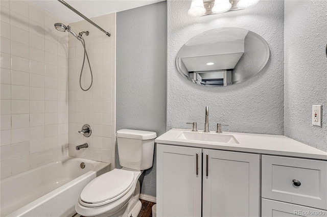 full bathroom featuring tiled shower / bath combo, toilet, and vanity