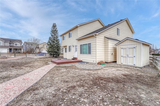 rear view of property with a storage shed and a wooden deck