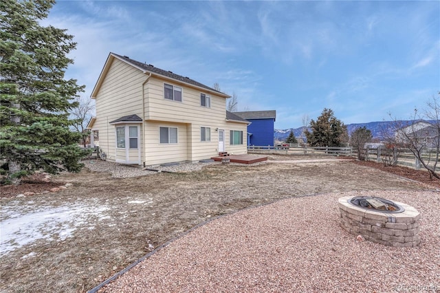 rear view of property featuring a mountain view and an outdoor fire pit