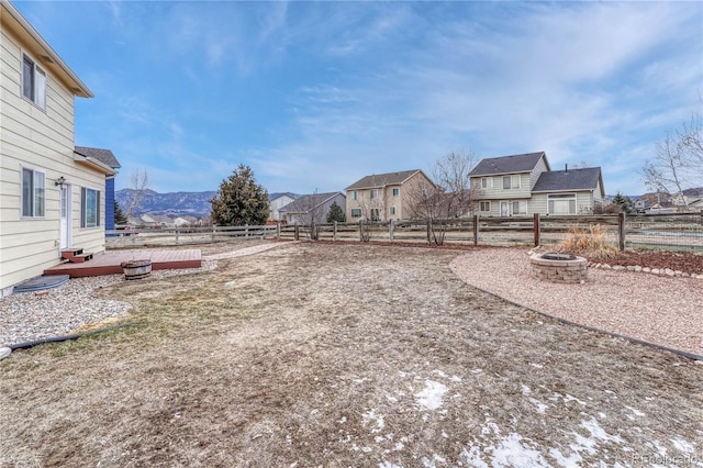 view of yard featuring a deck with mountain view and an outdoor fire pit