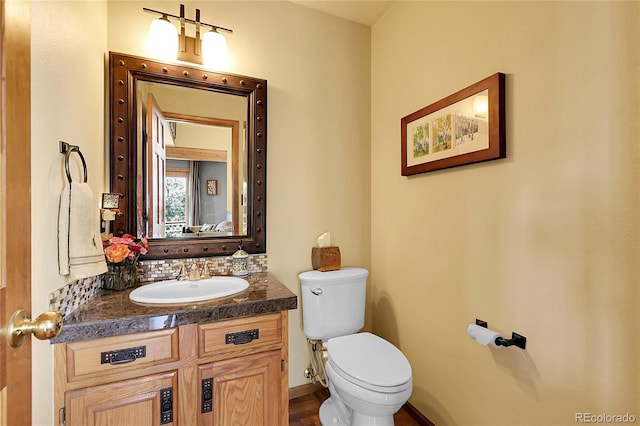 bathroom featuring vanity, tasteful backsplash, and toilet
