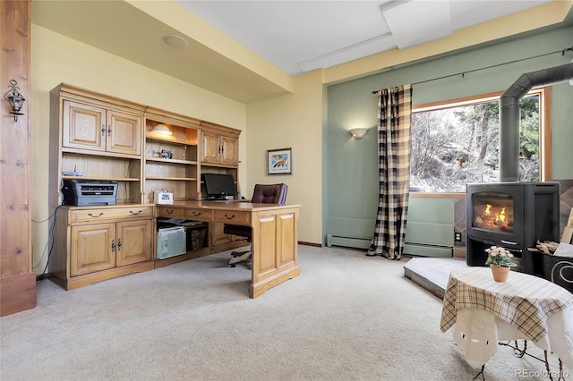 office area with a wood stove, a baseboard heating unit, and light carpet