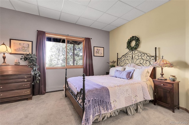 bedroom with baseboards, light colored carpet, and a paneled ceiling