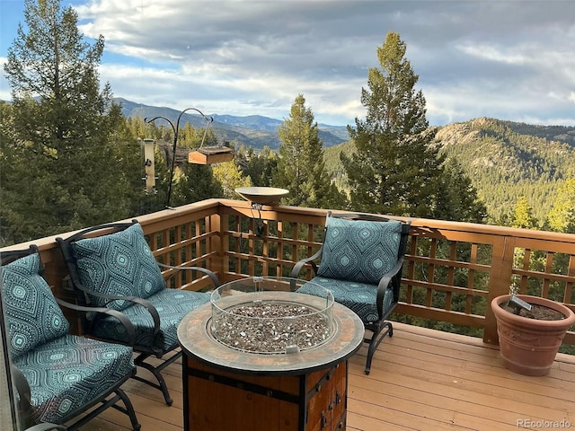 deck featuring a mountain view and an outdoor fire pit