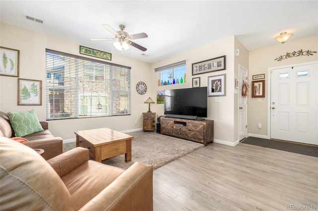 living room with ceiling fan and light hardwood / wood-style flooring