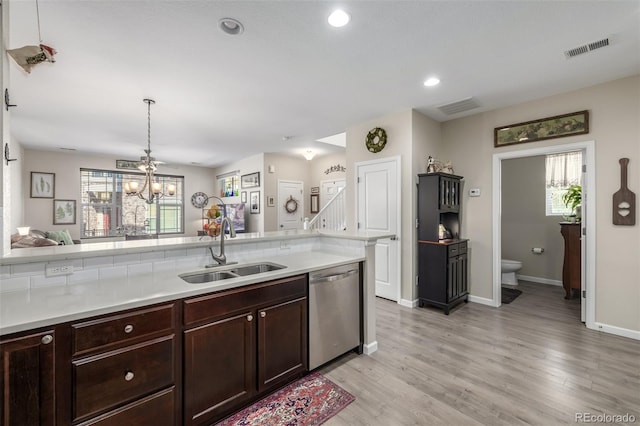 kitchen featuring dishwasher, sink, hanging light fixtures, light hardwood / wood-style flooring, and a chandelier