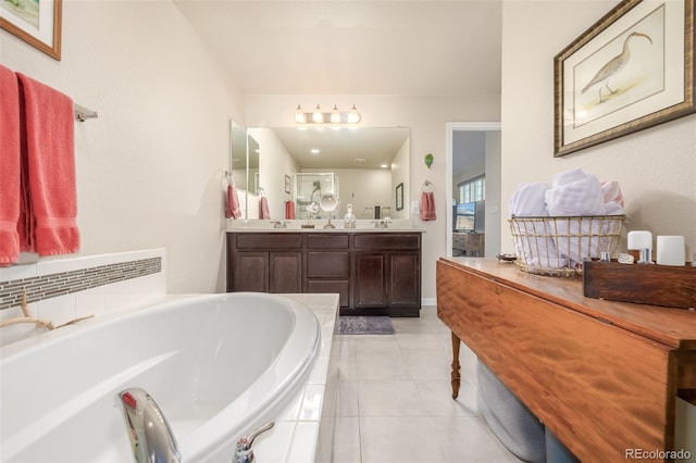 bathroom featuring tile patterned floors, vanity, and a relaxing tiled tub