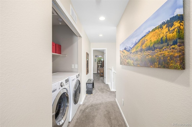 laundry area with washing machine and dryer and light colored carpet