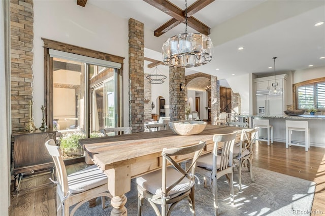 7767 Dante Dr, Littleton, CO 80125 - dining area with ornate columns, wood finished floors, beam ceiling, recessed lighting, and a chandelier